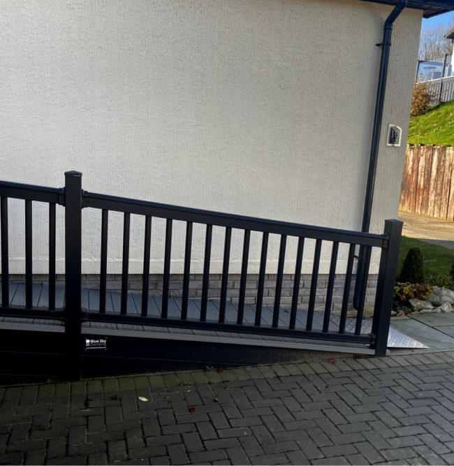 Black hand railing and ramp outside property