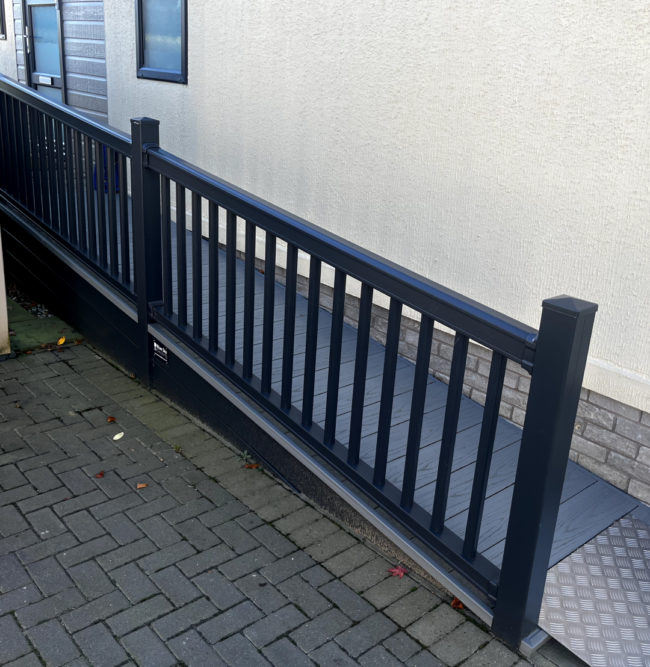 Black hand railing and ramp outside property