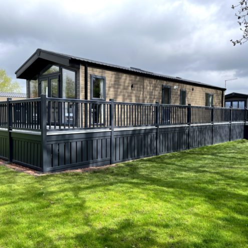 Dark grey and brown lodge with green grass and grey clouds
