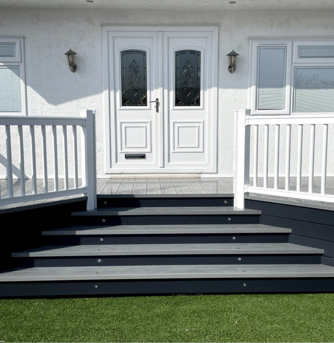 White dor with dark grey steps and green grass in front